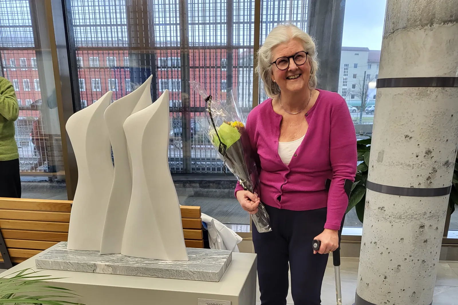 A woman holding a flower next to a white cake