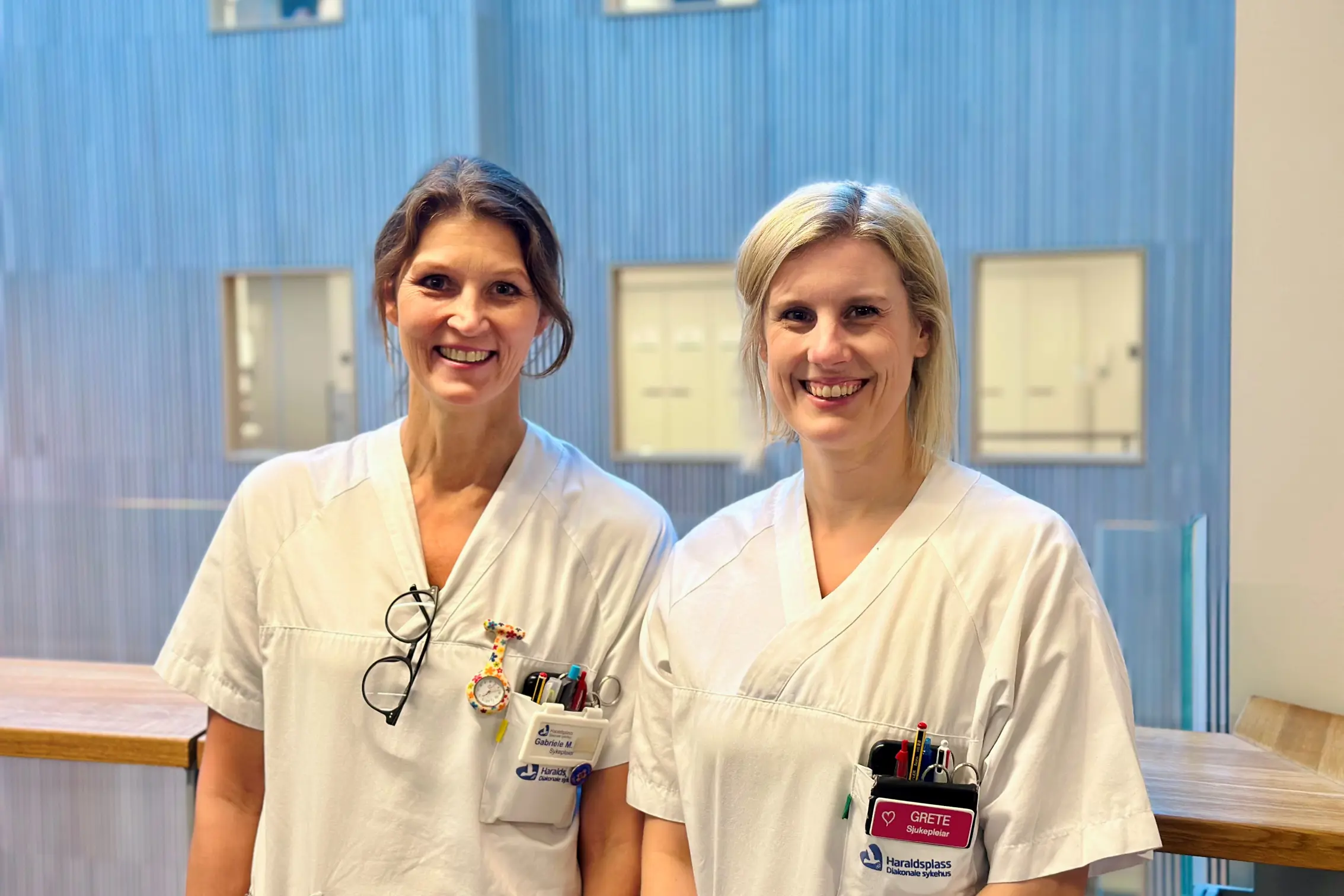 Et par kvinner iført hvite skjorter og merker