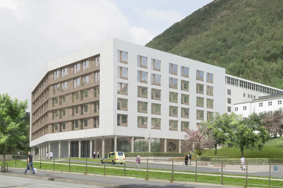 En stor hvit bygning med en høyde i bakgrunnen
