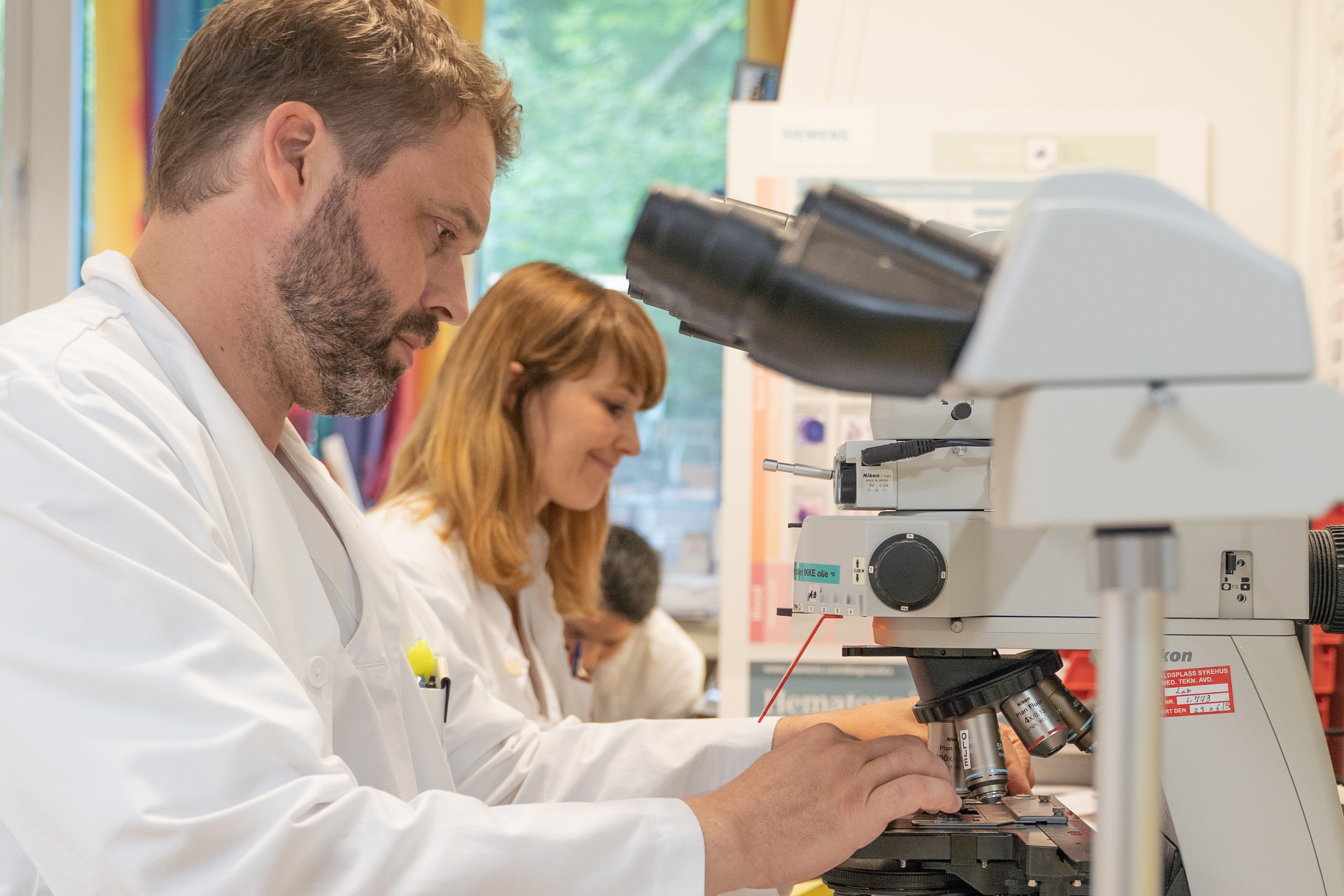 A man and a woman looking at a microscope