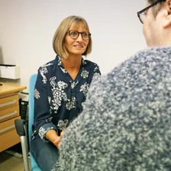 Forløpskoordinator Birthe Nesslin Bødker i samtale med pasient. foto