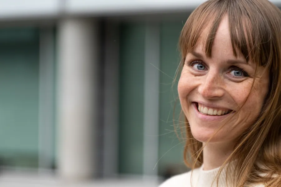 En kvinne som smiler med hånden i ansiktet