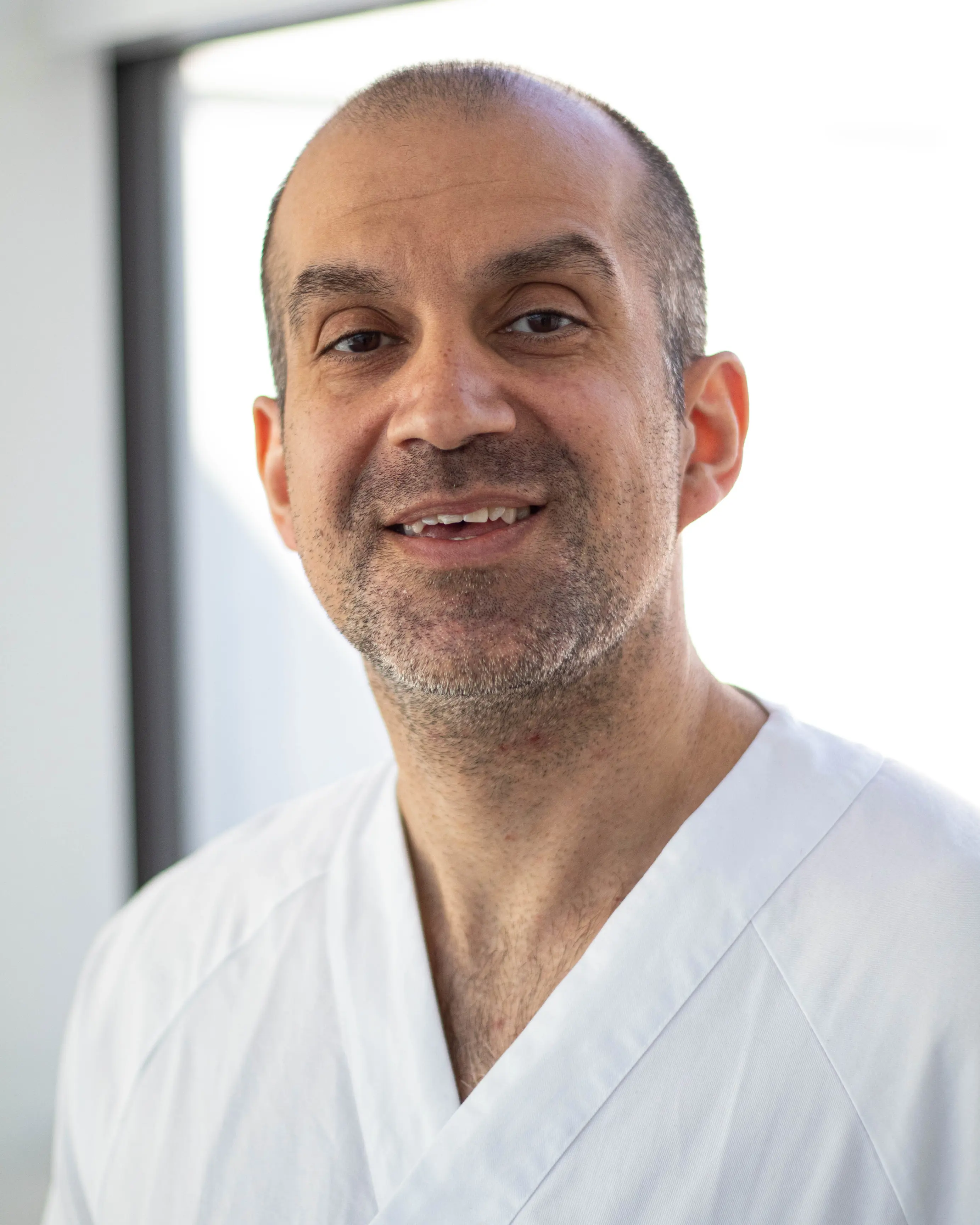 En mann som smiler til kameraet