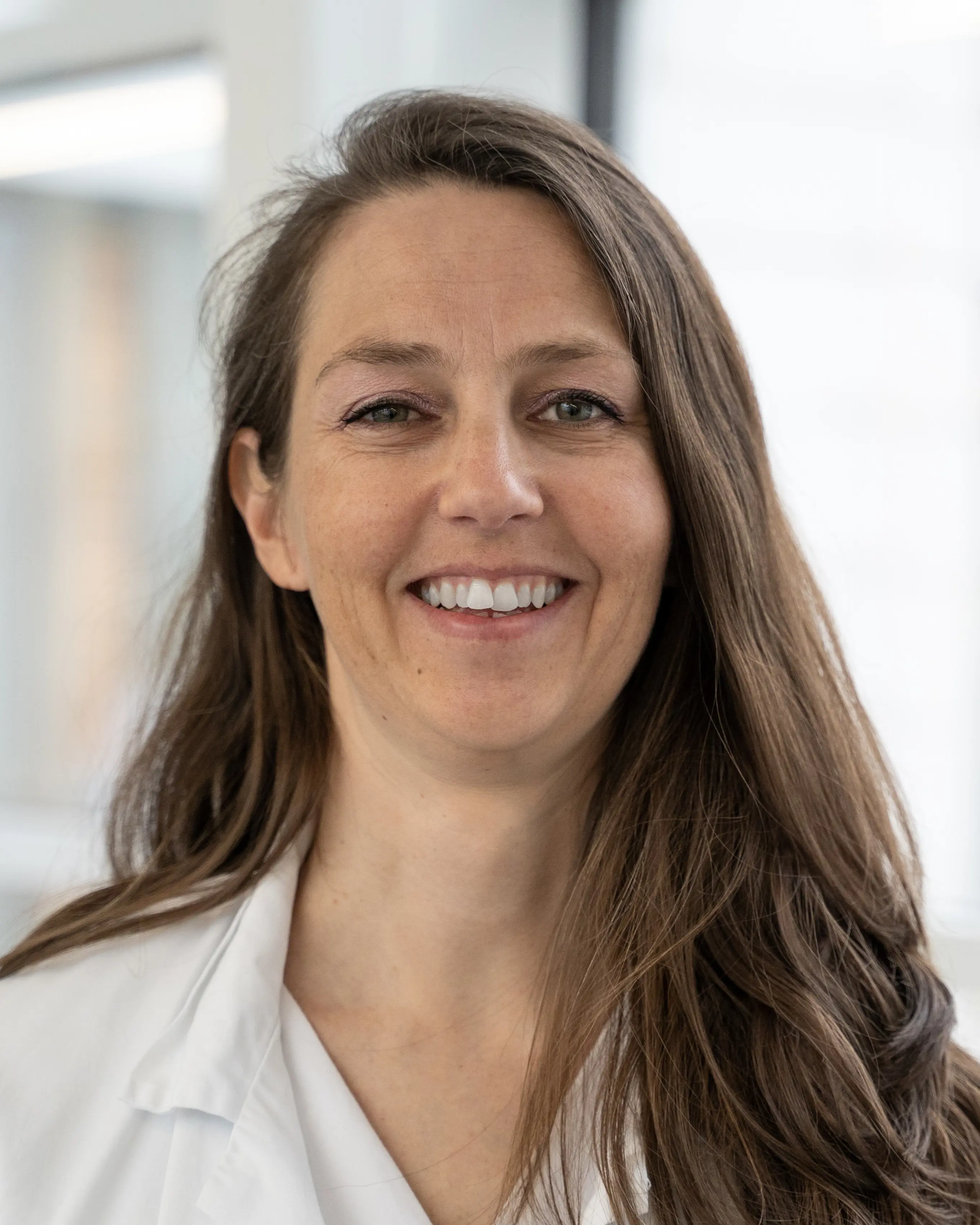 En kvinne med langt hår smilende