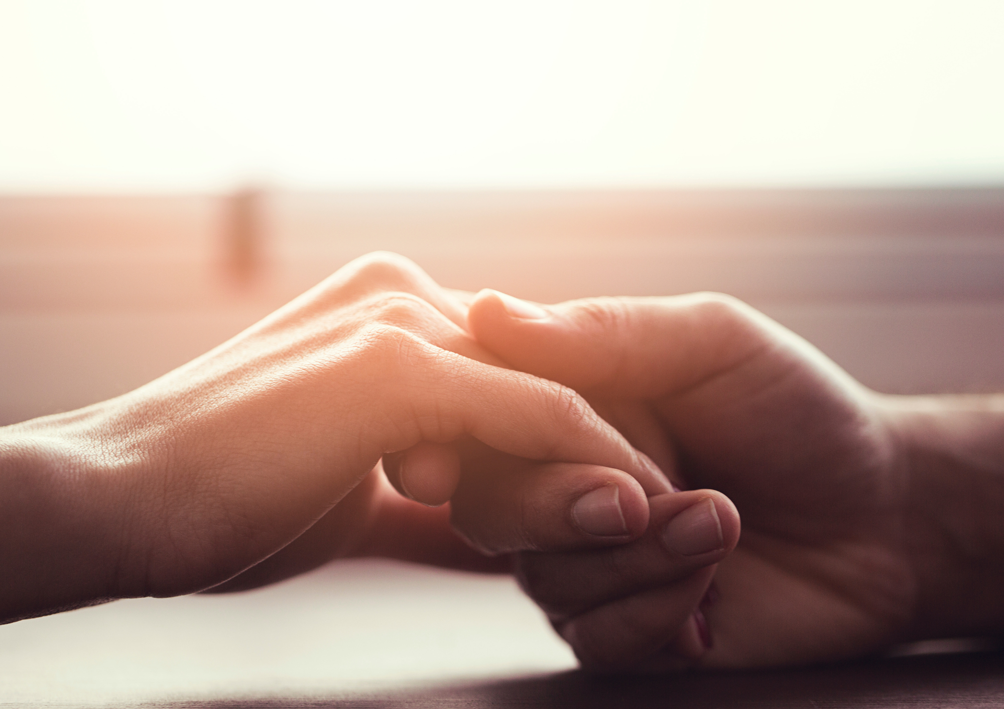 Et nærbilde av en person som holder en babys hånd