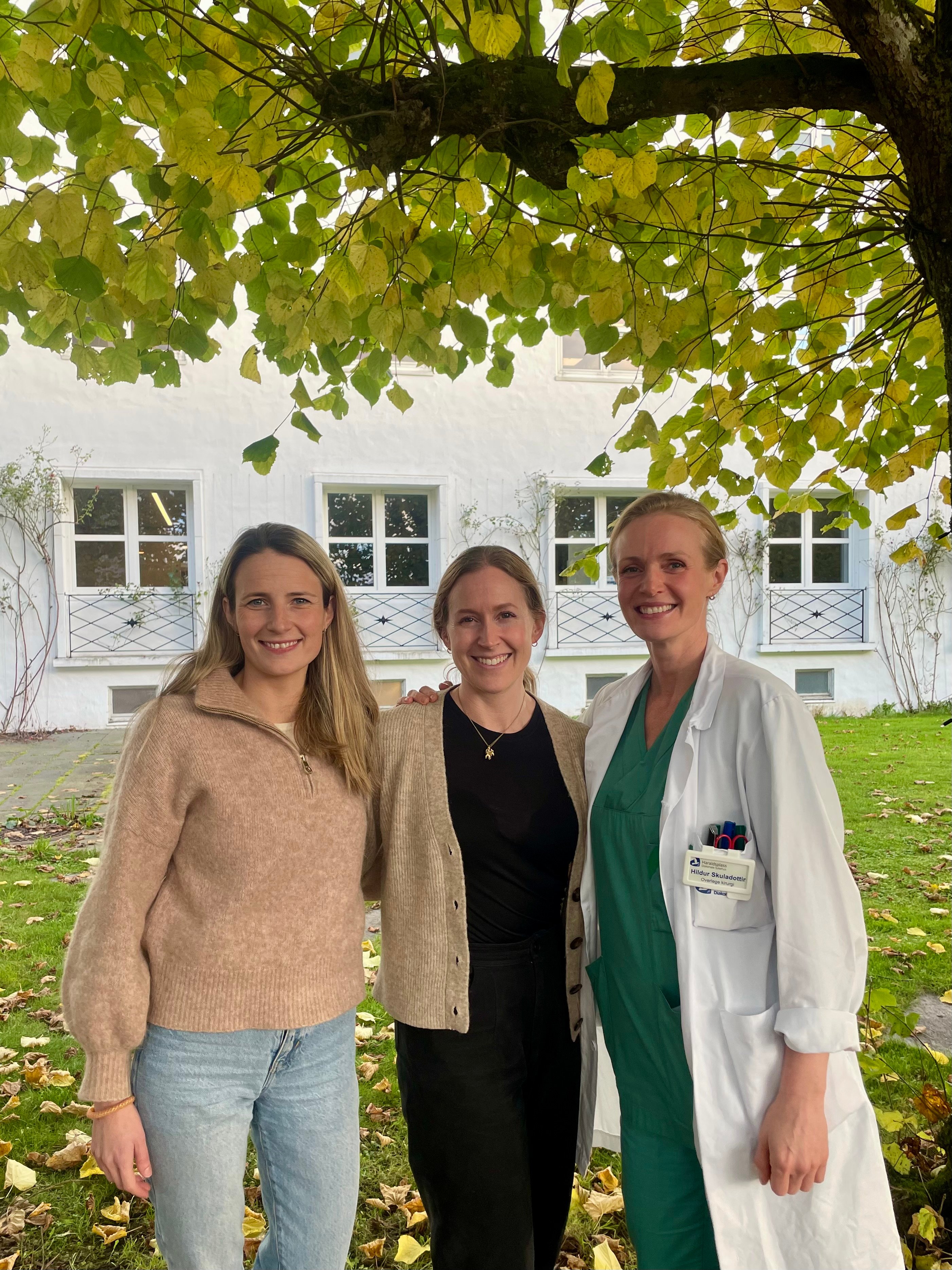 En gruppe kvinner som står under et tre