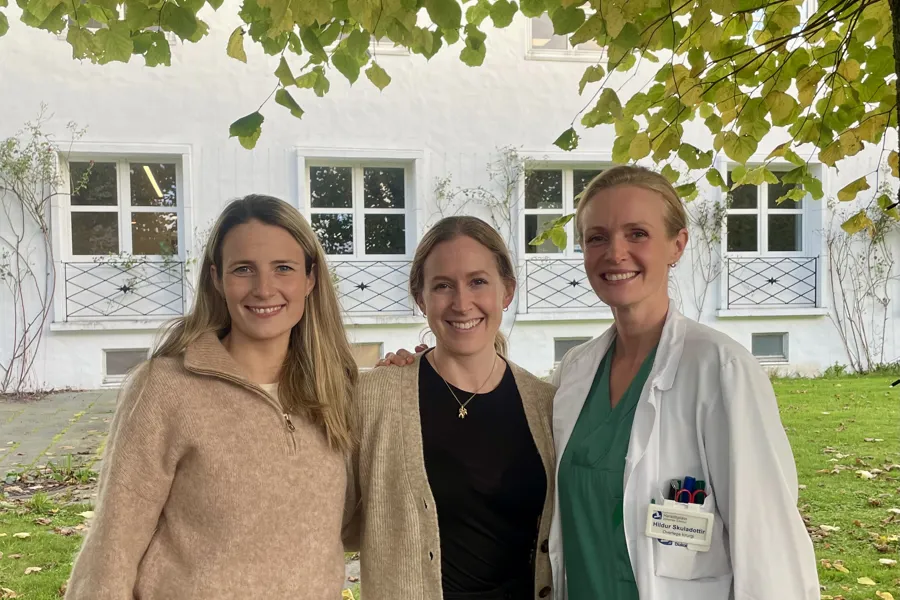 En gruppe kvinner som står under et tre